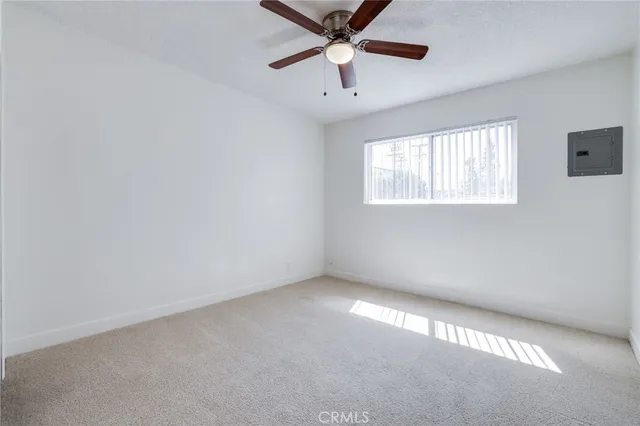 an empty room with windows and fan