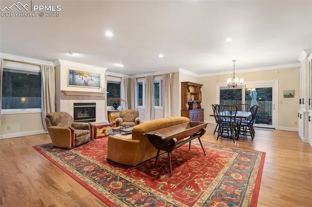a living room with furniture a fireplace and a dining table with wooden floor