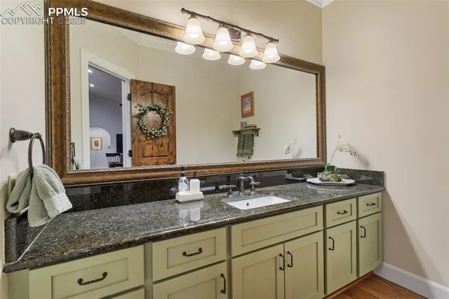 a bathroom with a granite countertop double vanity sink and mirror