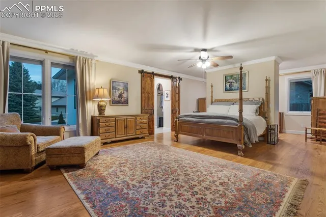 a spacious bedroom with a bed a couch and large windows