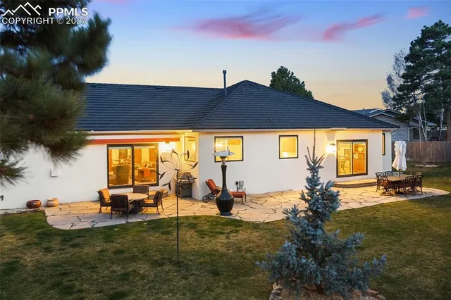 a backyard of a house with table and chairs