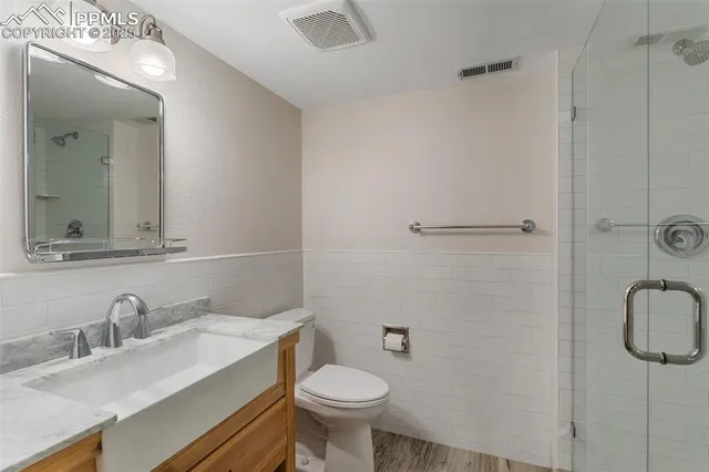 a bathroom with a granite countertop sink toilet and a mirror