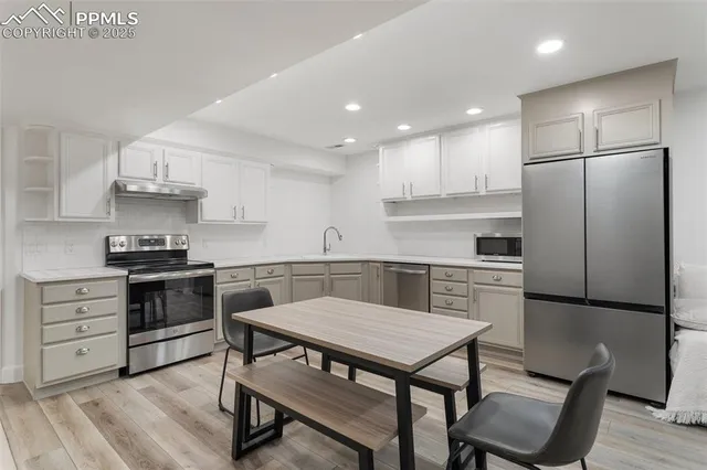a kitchen with cabinets wooden floor and stainless steel appliances