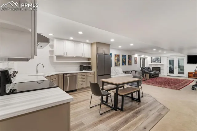 a kitchen with stainless steel appliances granite countertop a table chairs sink refrigerator and cabinets