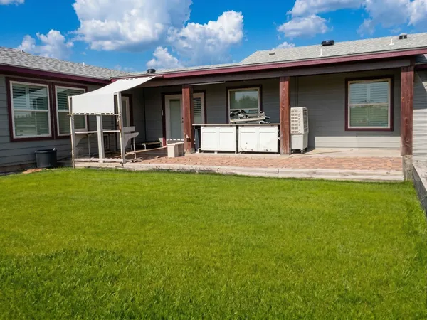 a big yard with lots of green space and house in back