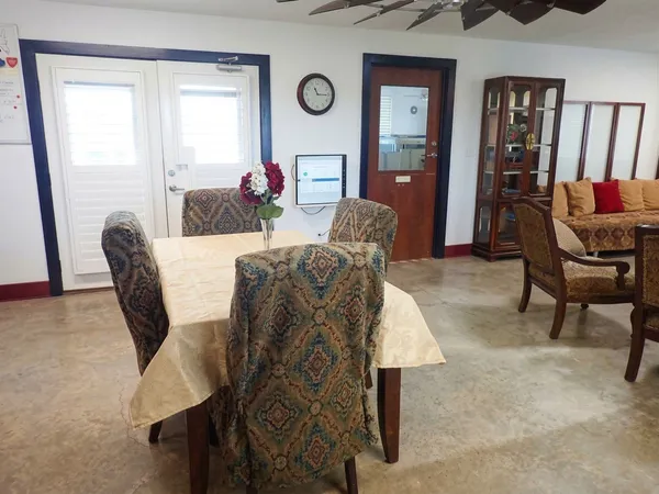 a living room with furniture and a dining table with kitchen appliances