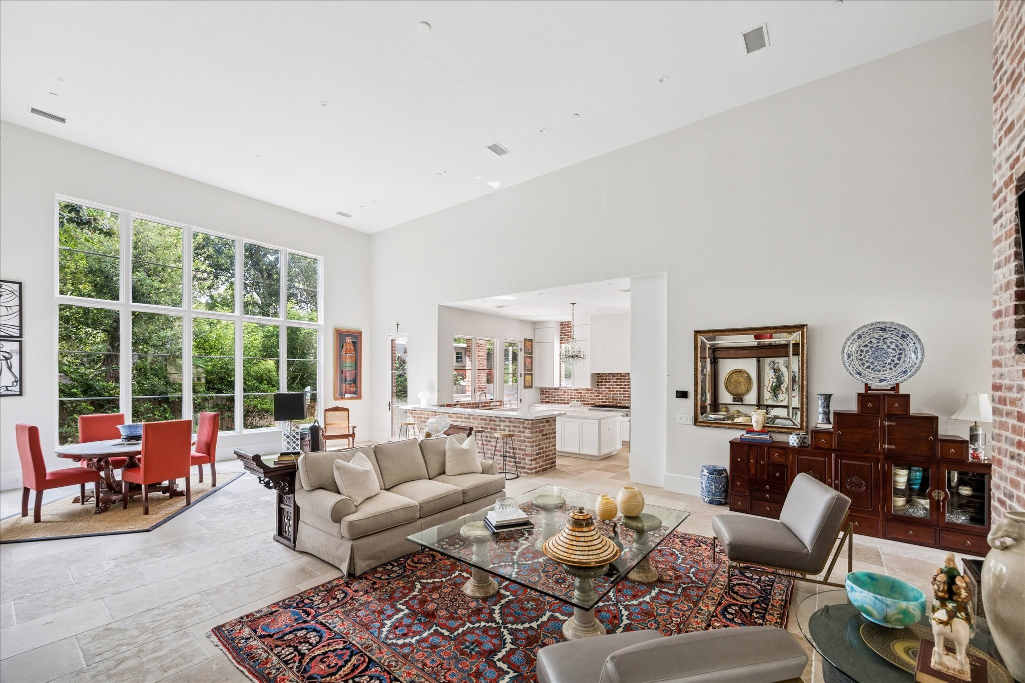 7 Hedwig Shadows Lane Houston, TX 77024 - Photo 15 of 46 Open-concept living at its finest—this thoughtfully designed space connects seamlessly to the kitchen and breakfast area. The palette of brick, limestone, and glass adds timeless character, while soaring ceilings emphasize light and volume. A refined balance of comfort and sophistication.