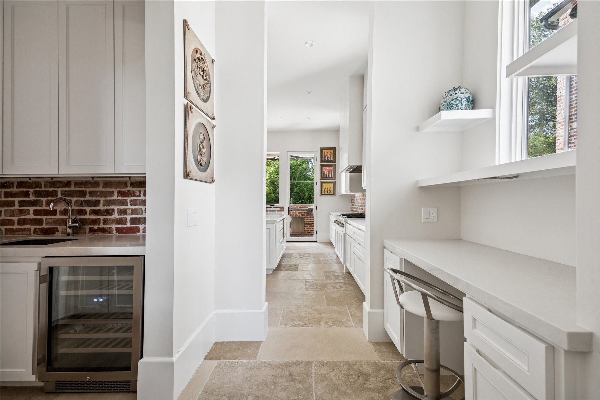 7 Hedwig Shadows Lane Houston, TX 77024 - Photo 18 of 46 This secondary prep area offers additional storage, stone counters, and a dedicated workstation—perfect for catering or keeping the main kitchen pristine during gatherings. Custom built-ins and natural light enhance its refined practicality.