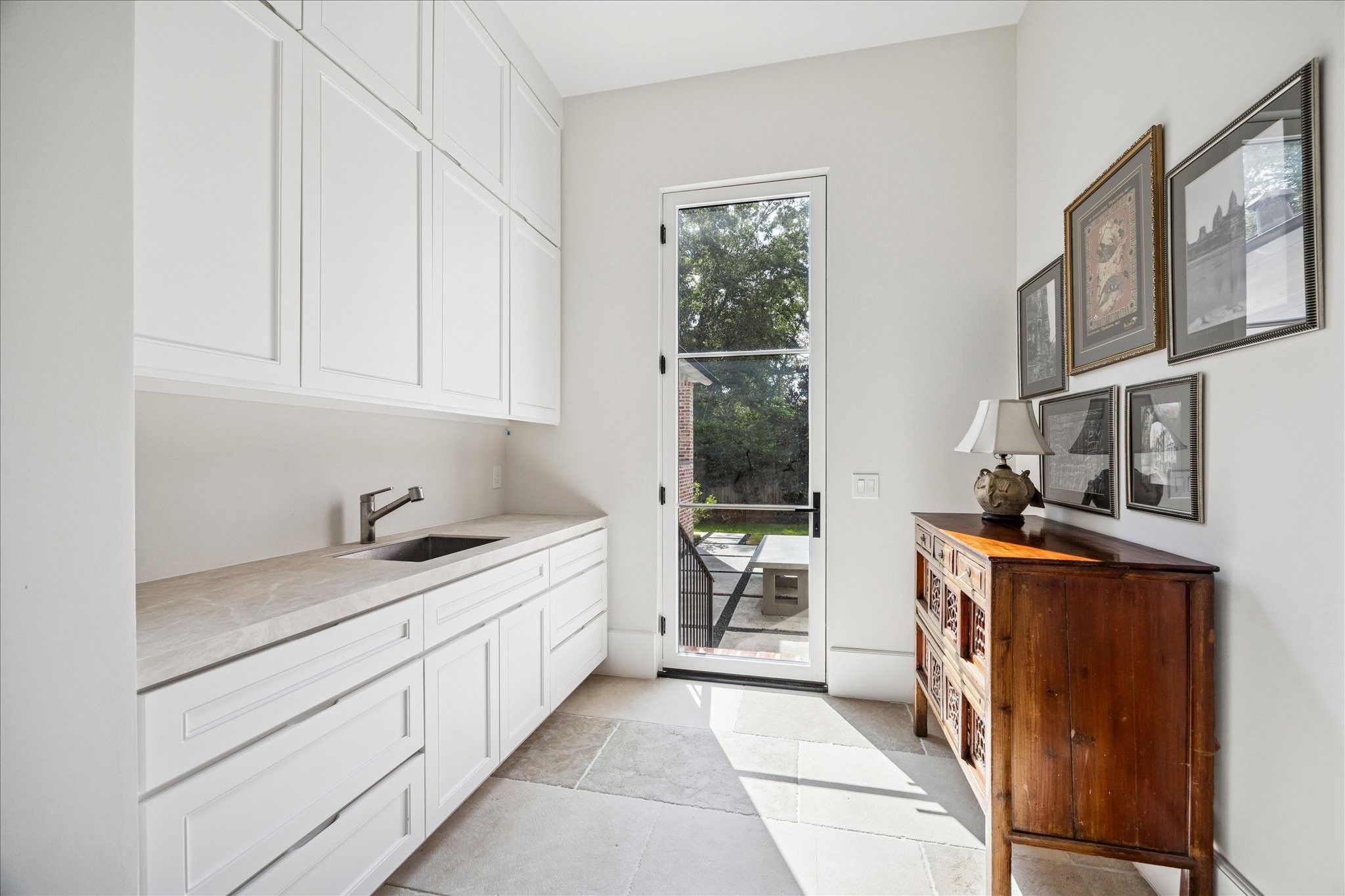 7 Hedwig Shadows Lane Houston, TX 77024 - Photo 23 of 46 A thoughtfully designed utility space with custom cabinetry, sink, and outdoor access. Clean lines and soft natural tones create a serene, functional environment that complements the home’s cohesive aesthetic.