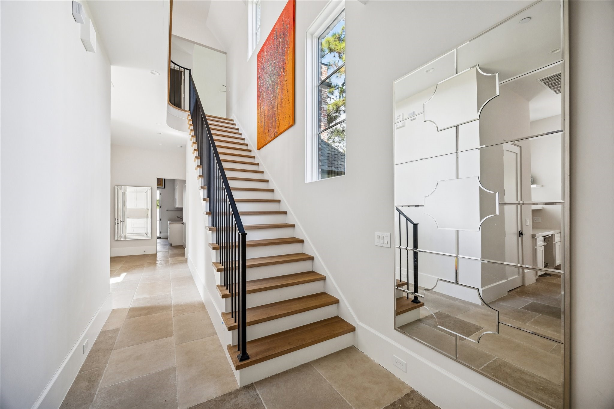 7 Hedwig Shadows Lane Houston, TX 77024 - Photo 29 of 46 The architectural staircase makes a sculptural statement with its natural oak treads, black iron balustrade, and artful geometry. Framed by large windows and an eye-catching mirrored wall, the space seamlessly connects both levels of the home with elegance and light.