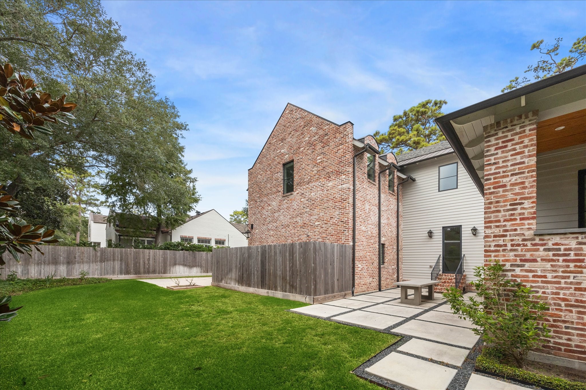 7 Hedwig Shadows Lane Houston, TX 77024 - Photo 40 of 46 Expansive and private, the backyard provides an ideal canvas for outdoor living. The home’s brick and siding exterior blends classic craftsmanship with modern simplicity, while the concrete paver terrace offers a stylish foundation for entertaining or relaxation.