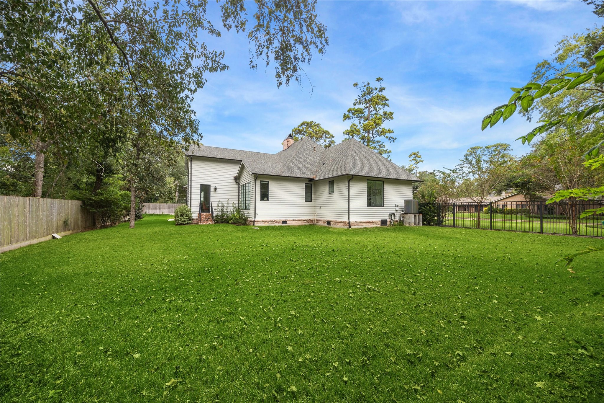 7 Hedwig Shadows Lane Houston, TX 77024 - Photo 42 of 46 A sweeping stretch of manicured lawn bordered by mature trees creates a serene natural backdrop. The generous scale of the yard offers room for a pool, play area, or future garden design—perfect for both entertaining and quiet retreat.