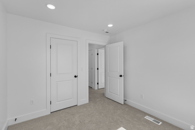 248 West 2920th Street South Logan, UT 84321 - Photo 45 of 47 Light-colored carpeted flooring with white painted walls, recessed lighting, and white two-panel doors with matte black hardware