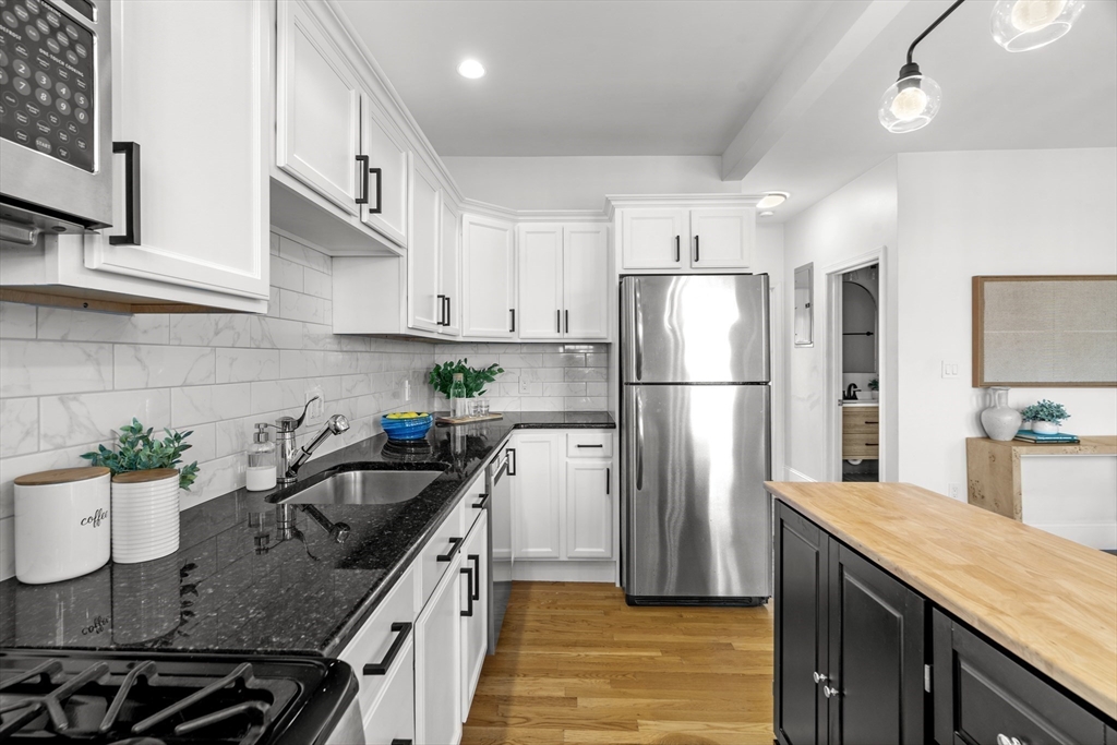 15 I Street, Unit 3 Boston, MA 02127 - Photo 3 of 17 a kitchen with stainless steel appliances granite countertop a sink stove and refrigerator