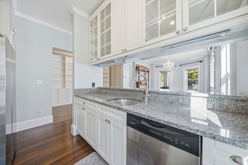 33 Adams Street, Unit 1 Boston, MA 02122 - Photo 11 of 36 a kitchen with stainless steel appliances granite countertop a sink and dishwasher with wooden floor