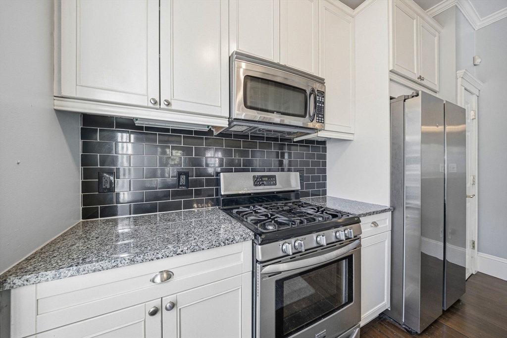 33 Adams Street, Unit 1 Boston, MA 02122 - Photo 13 of 36 a kitchen with granite countertop a stove sink and microwave