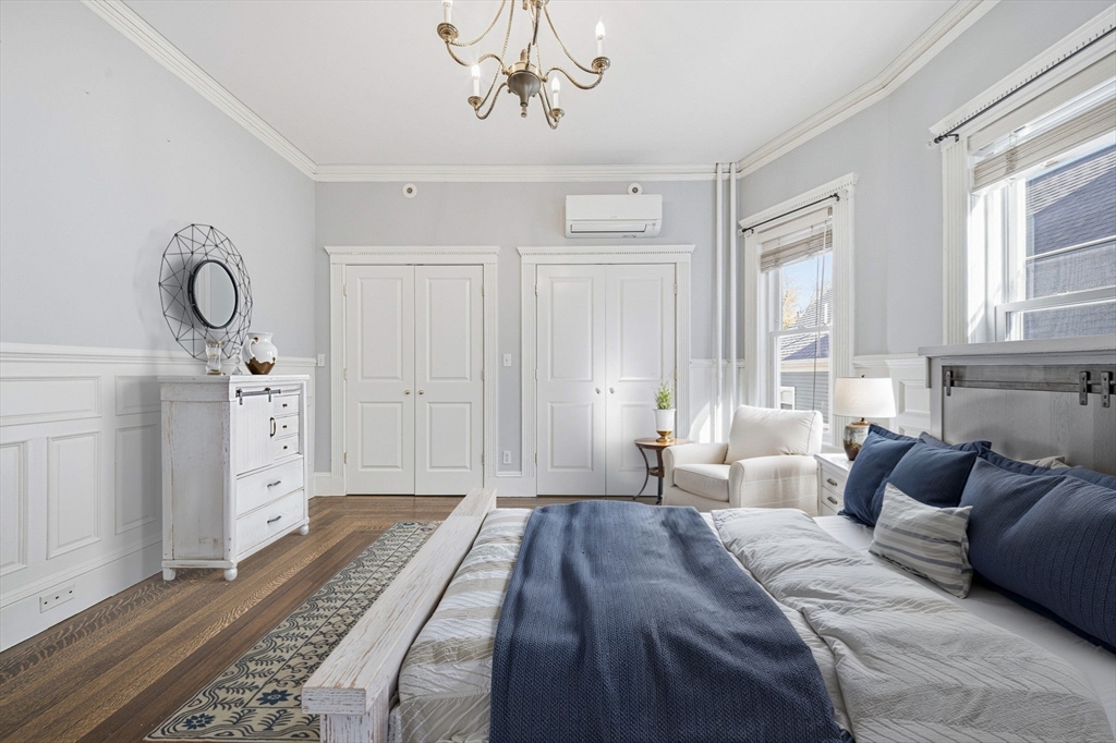 33 Adams Street, Unit 1 Boston, MA 02122 - Photo 18 of 36 a bedroom with a large bed and a chandelier