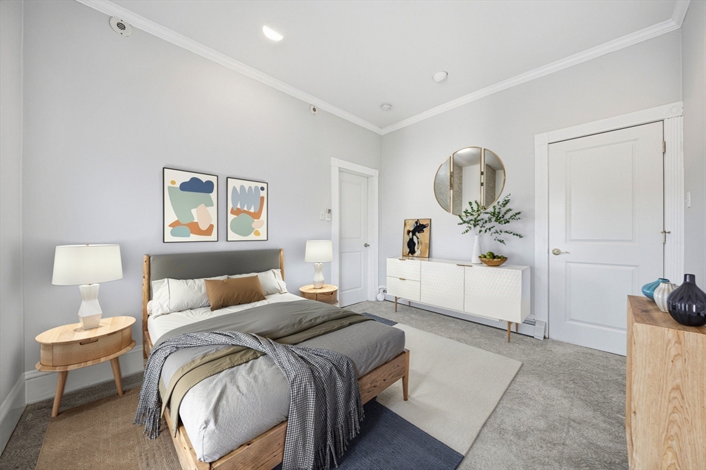 33 Adams Street, Unit 1 Boston, MA 02122 - Photo 22 of 36 a bedroom with a bed and a chandelier