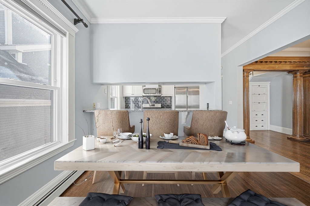 33 Adams Street, Unit 1 Boston, MA 02122 - Photo 9 of 36 a kitchen with a table chairs and wooden floor