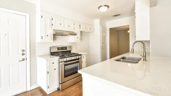 a kitchen with stainless steel appliances granite countertop a sink and a stove