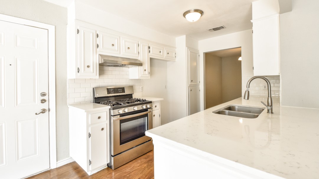 910 Rocky Spring Road Austin, TX 78753 - Photo 12 of 26 a kitchen with stainless steel appliances granite countertop a sink and a stove