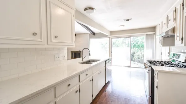 a kitchen with a sink stove and cabinets
