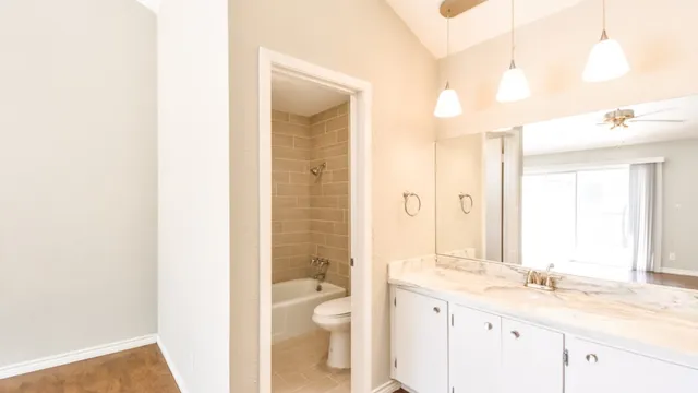 a bathroom with a granite countertop sink a toilet and a shower
