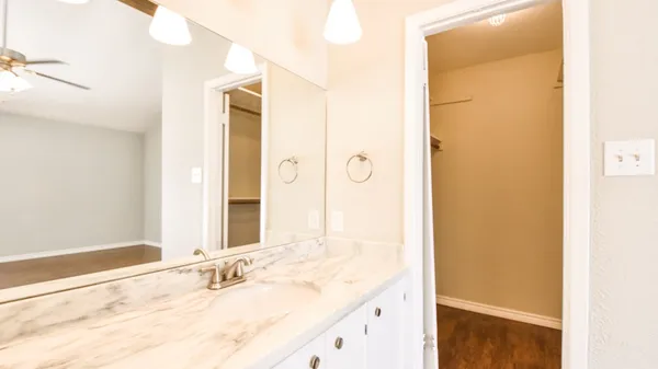 a bathroom with a granite countertop sink and a mirror