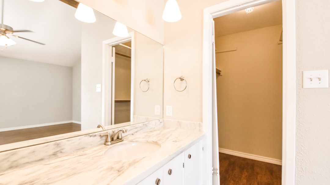 910 Rocky Spring Road Austin, TX 78753 - Photo 17 of 26 a bathroom with a granite countertop sink and a mirror