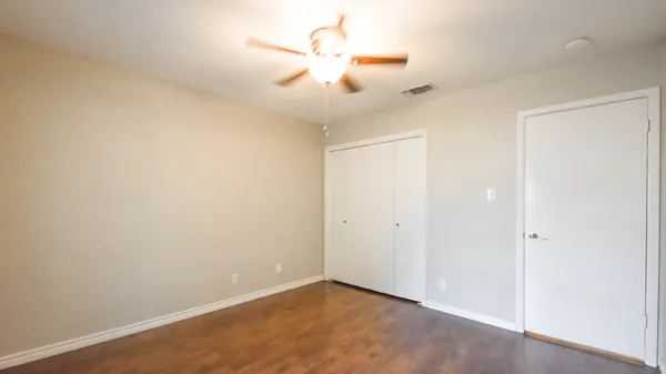 an empty room with a ceiling fan and a window