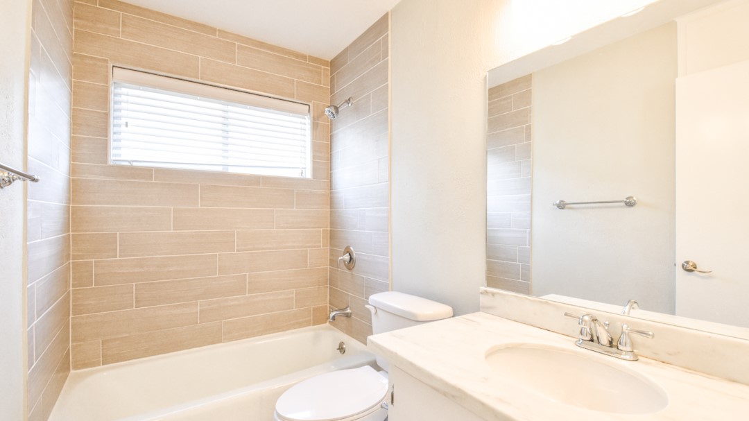 910 Rocky Spring Road Austin, TX 78753 - Photo 21 of 26 a bathroom with a granite countertop sink toilet and shower