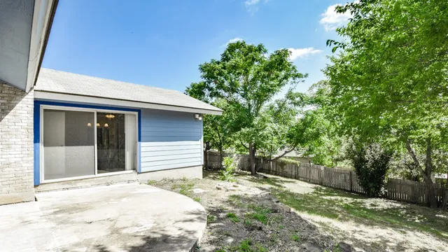 a backyard of a house with plants and trees