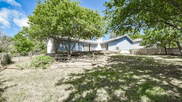 a front view of house with yard and trees around