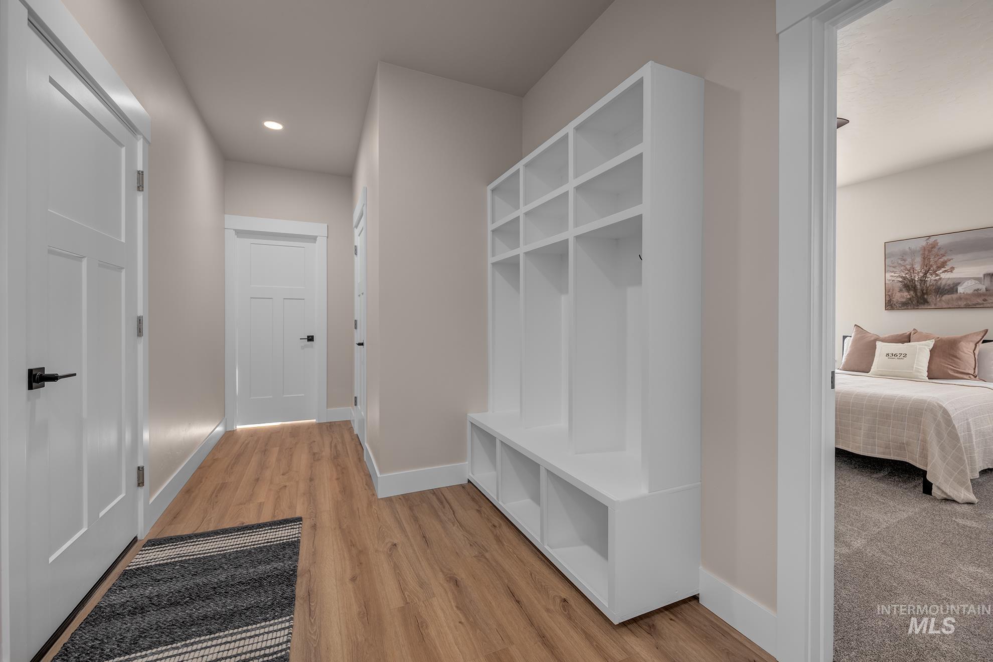 1371 Hansen Road Weiser, ID 83672 - Photo 18 of 44 Wood-finish flooring, recessed lighting, white built-in storage with cubbies, white interior doors with black hardware, and neutral wall tones