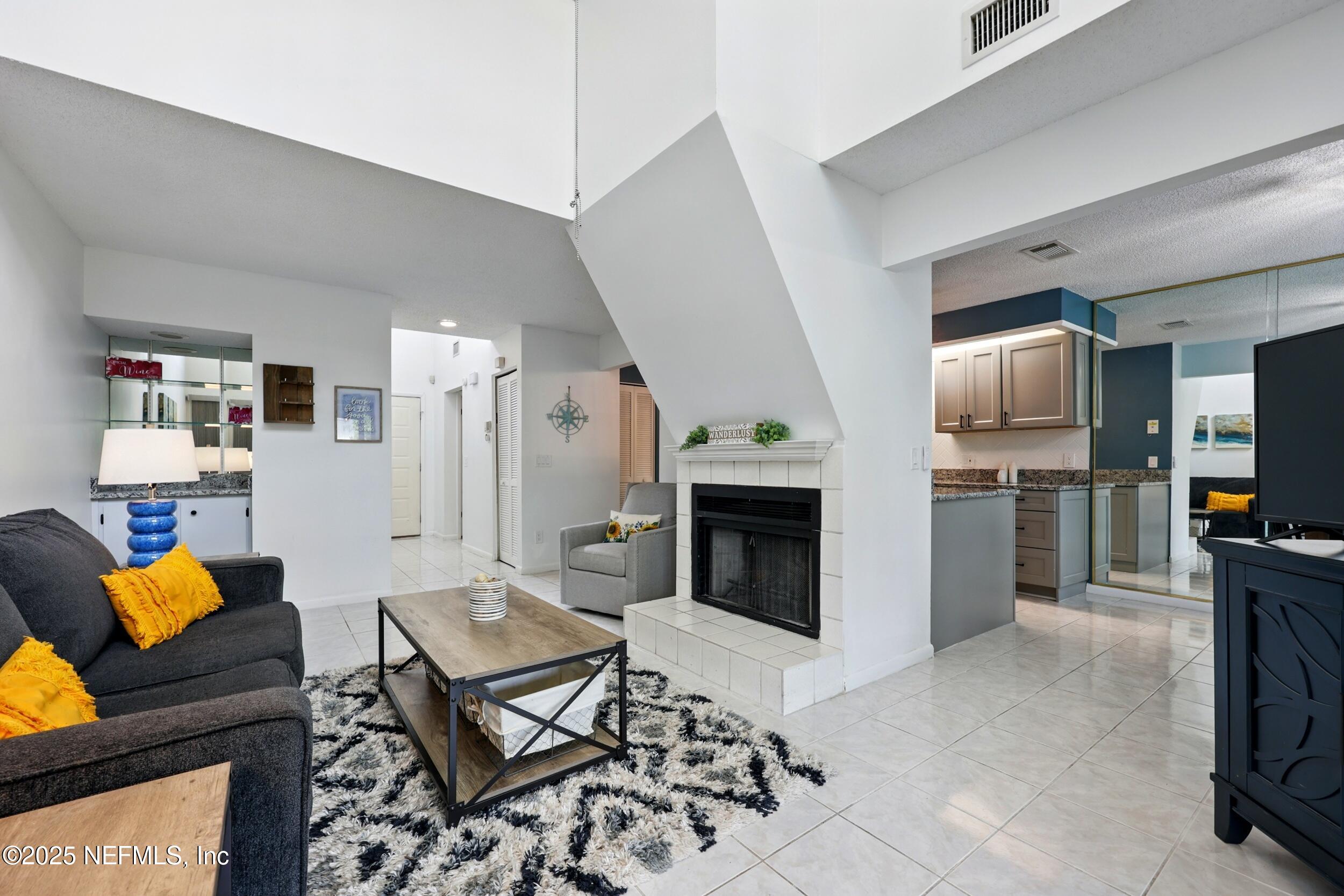 9360 Craven Road, Unit 1406 Jacksonville, FL 32257 - Photo 11 of 30 a living room with furniture a flat screen tv and a fireplace