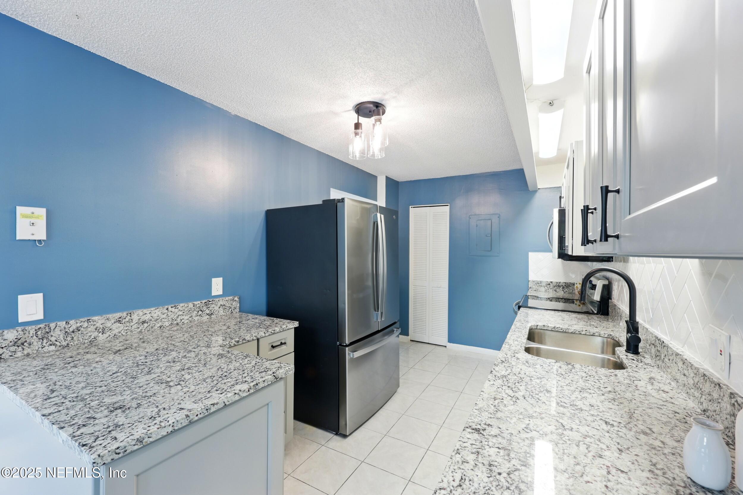 9360 Craven Road, Unit 1406 Jacksonville, FL 32257 - Photo 13 of 30 a kitchen with stainless steel appliances granite countertop sink refrigerator and stove