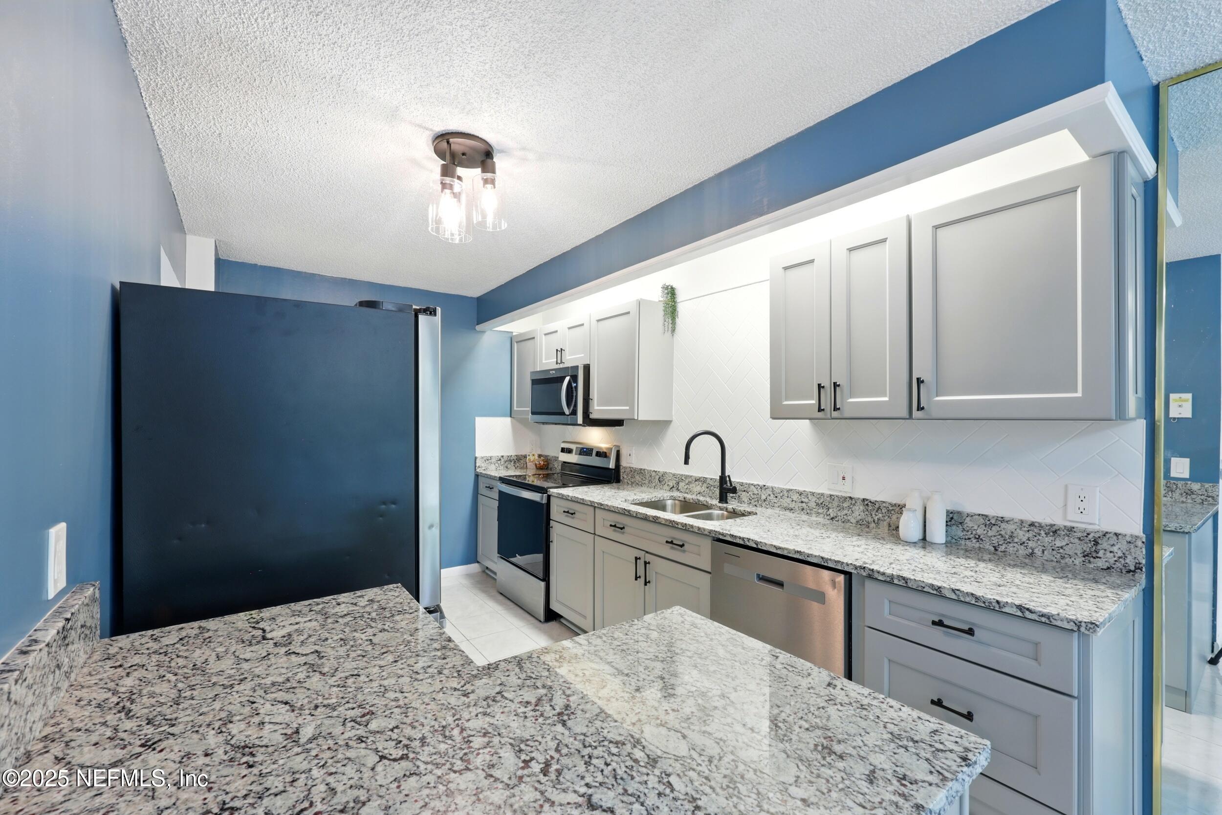 9360 Craven Road, Unit 1406 Jacksonville, FL 32257 - Photo 16 of 30 a kitchen with a sink stove and refrigerator