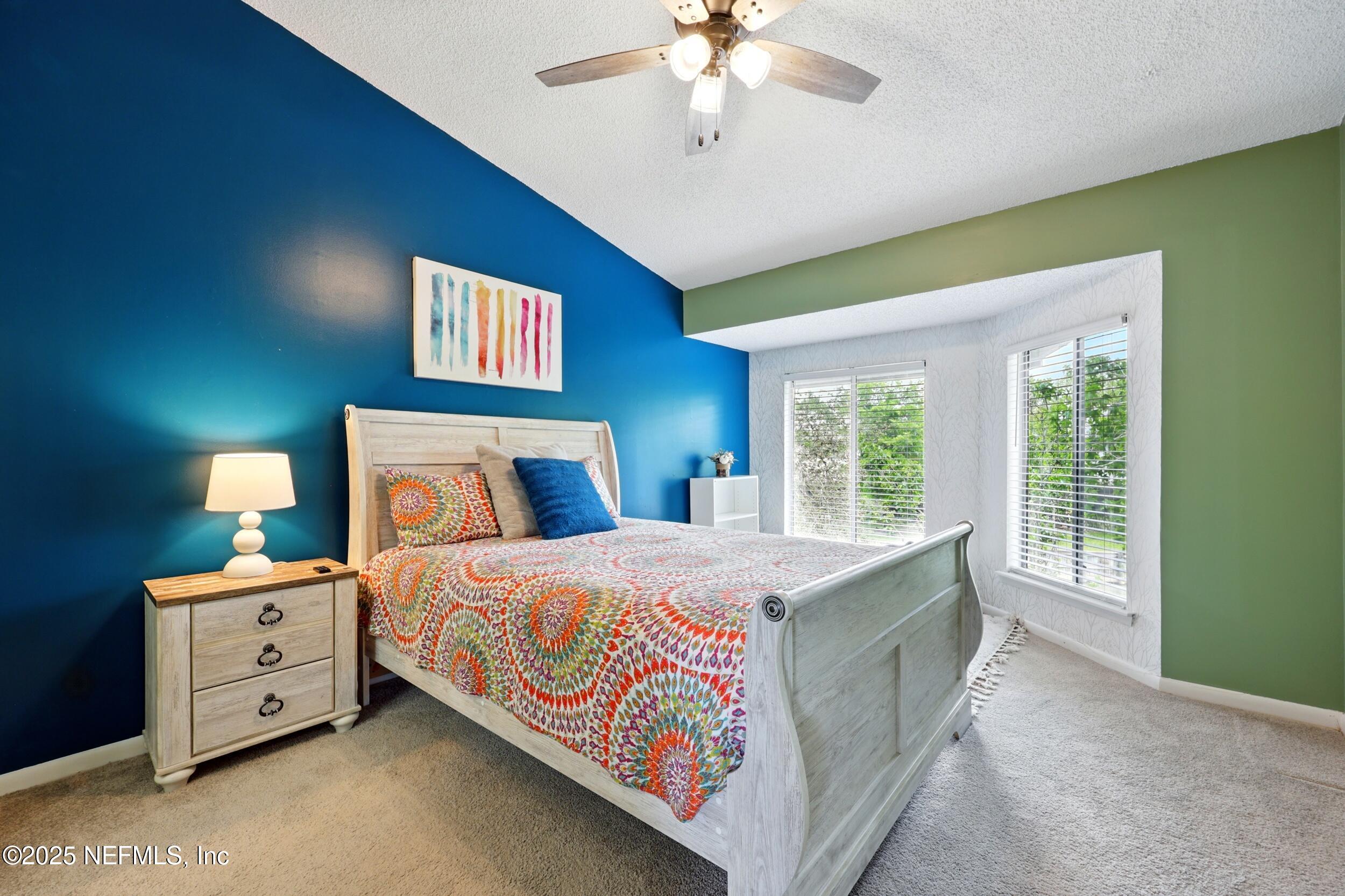 9360 Craven Road, Unit 1406 Jacksonville, FL 32257 - Photo 17 of 30 a bedroom with a bed and a chandelier