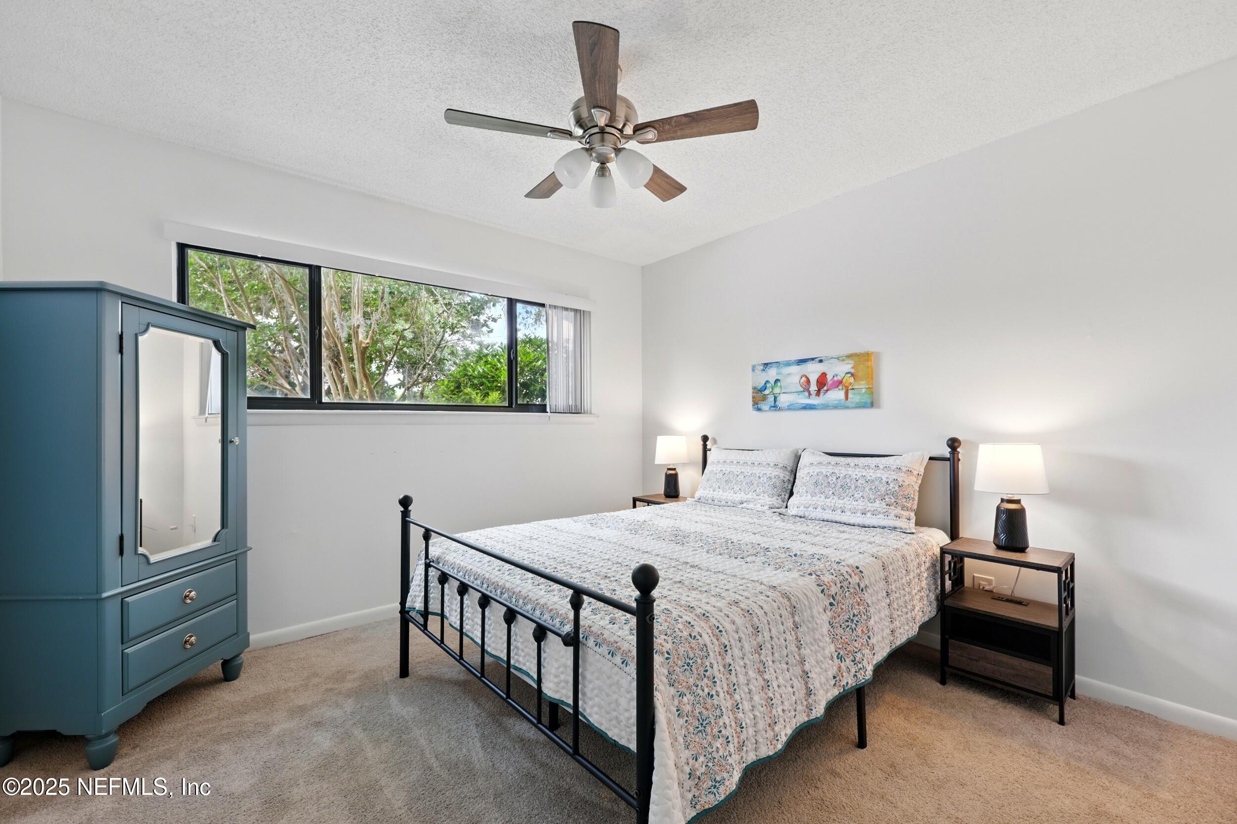 9360 Craven Road, Unit 1406 Jacksonville, FL 32257 - Photo 22 of 30 a bedroom with a bed and a refrigerator