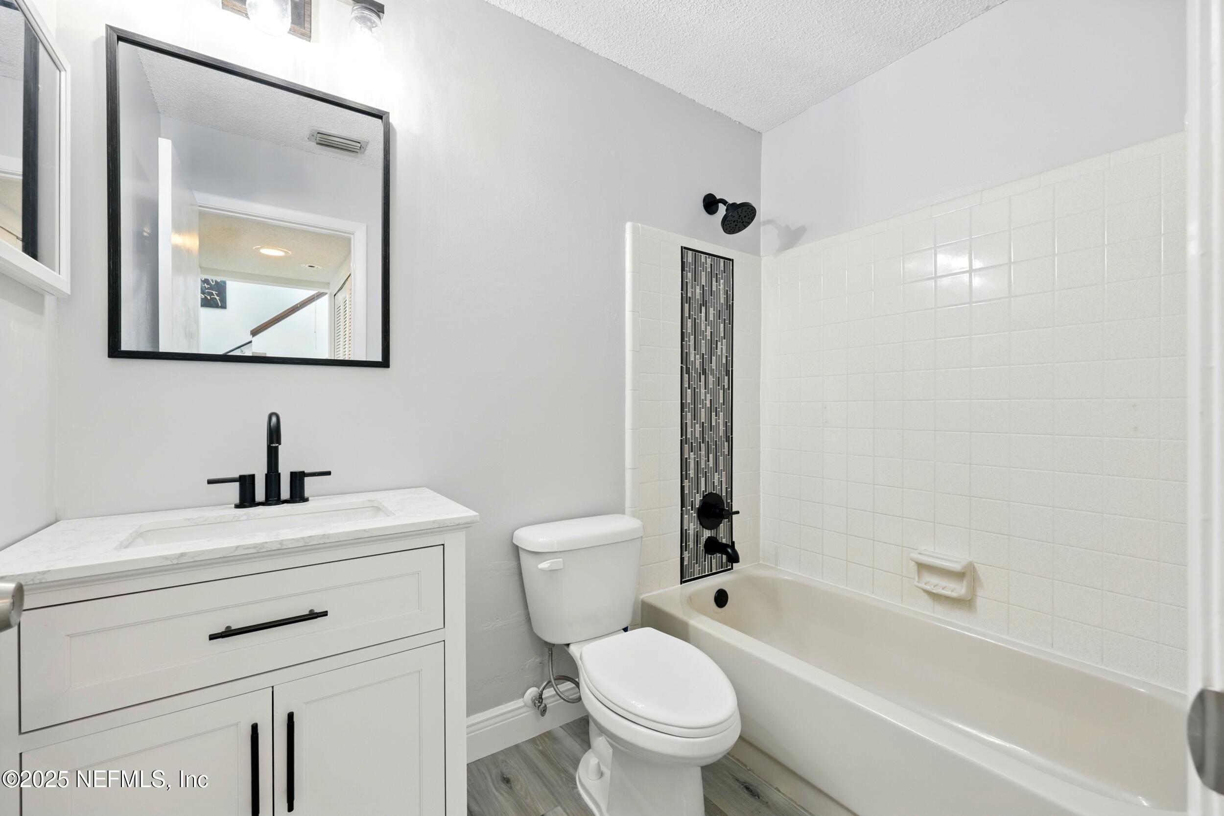 9360 Craven Road, Unit 1406 Jacksonville, FL 32257 - Photo 24 of 30 a bathroom with a toilet sink vanity tub and shower