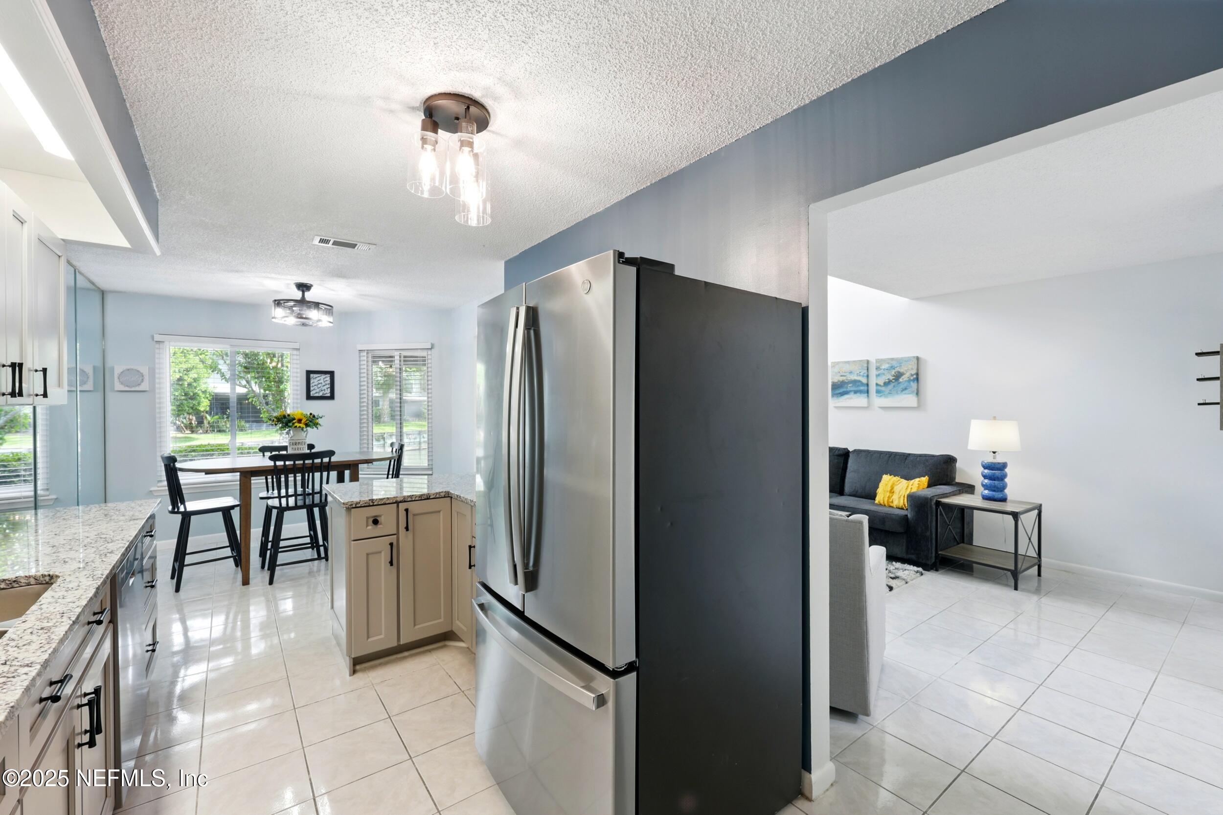 9360 Craven Road, Unit 1406 Jacksonville, FL 32257 - Photo 8 of 30 a kitchen with stainless steel appliances a refrigerator and a stove