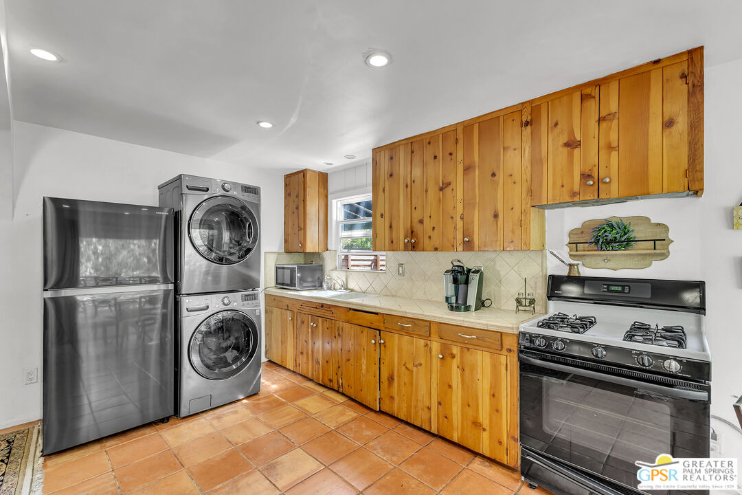 25300 Tahquitz Road Idyllwild, CA 92549 - Photo 27 of 75 a kitchen with a stove top oven sink and cabinets