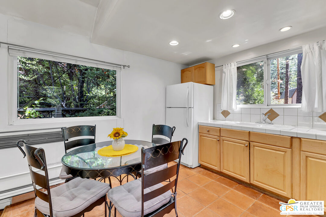25300 Tahquitz Road Idyllwild, CA 92549 - Photo 71 of 75 a kitchen with a table chairs sink and refrigerator