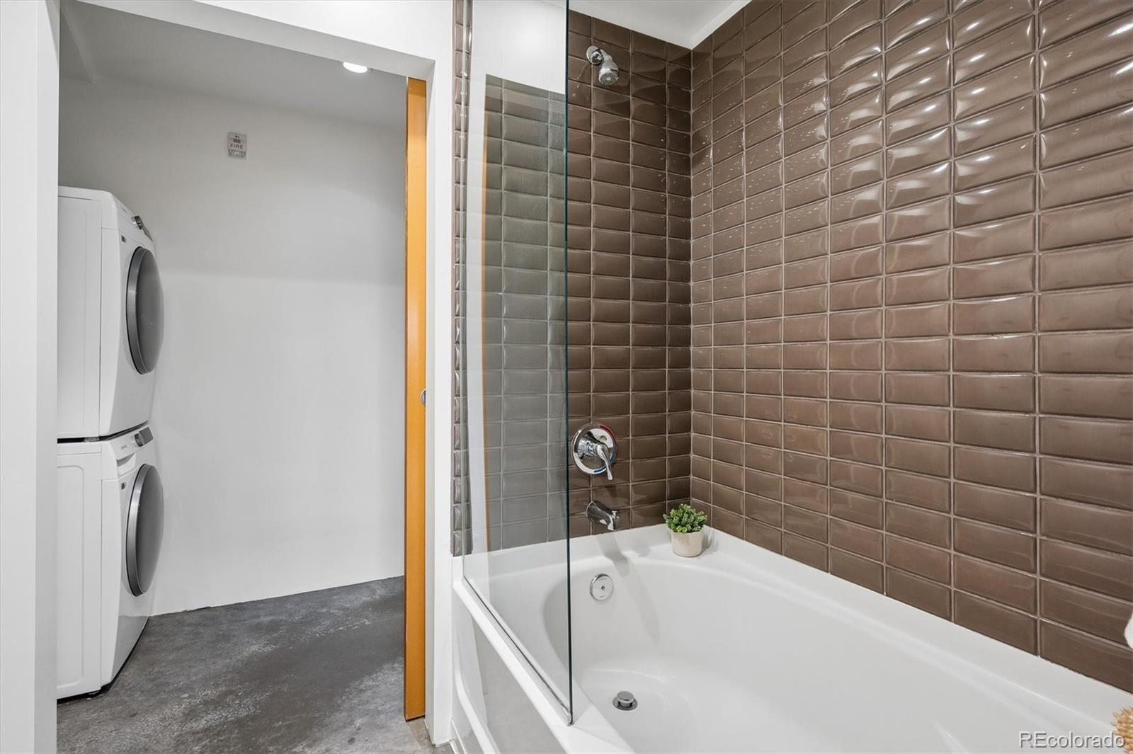 3457 Ringsby Court, Unit 347 Denver, CO 80216 - Photo 16 of 22 a bathroom with a tub and a shower