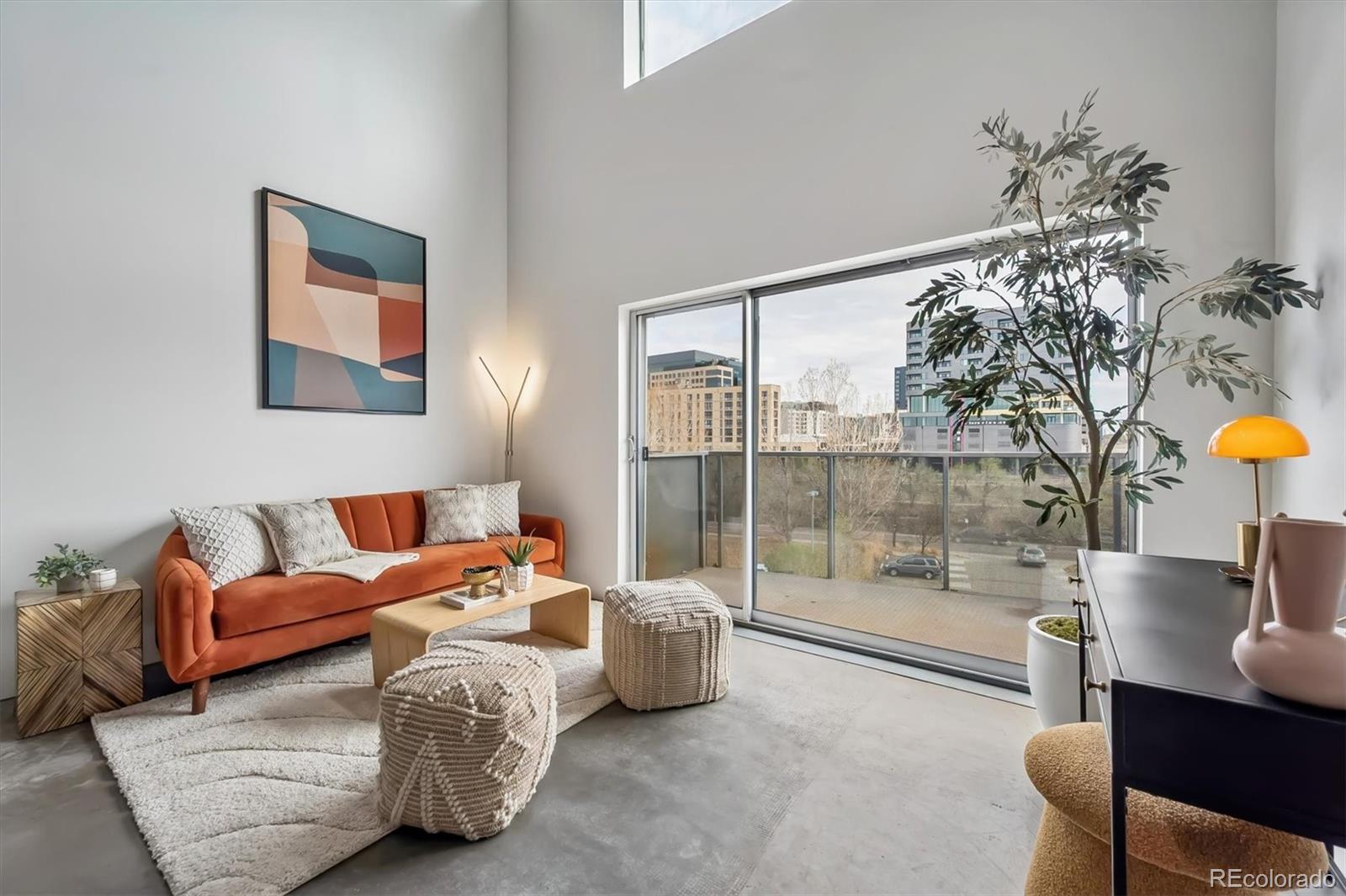 3457 Ringsby Court, Unit 347 Denver, CO 80216 - Photo 4 of 22 a bedroom with furniture and a large window
