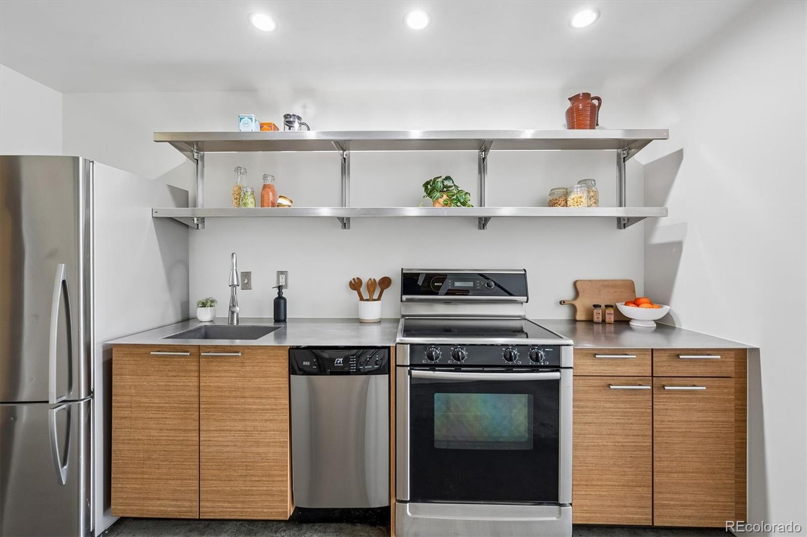 3457 Ringsby Court, Unit 347 Denver, CO 80216 - Photo 5 of 22 a kitchen with stainless steel appliances granite countertop a sink and a stove