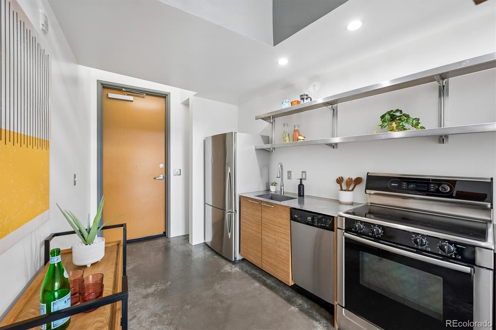 3457 Ringsby Court, Unit 347 Denver, CO 80216 - Photo 6 of 22 a kitchen with stainless steel appliances a sink and a refrigerator