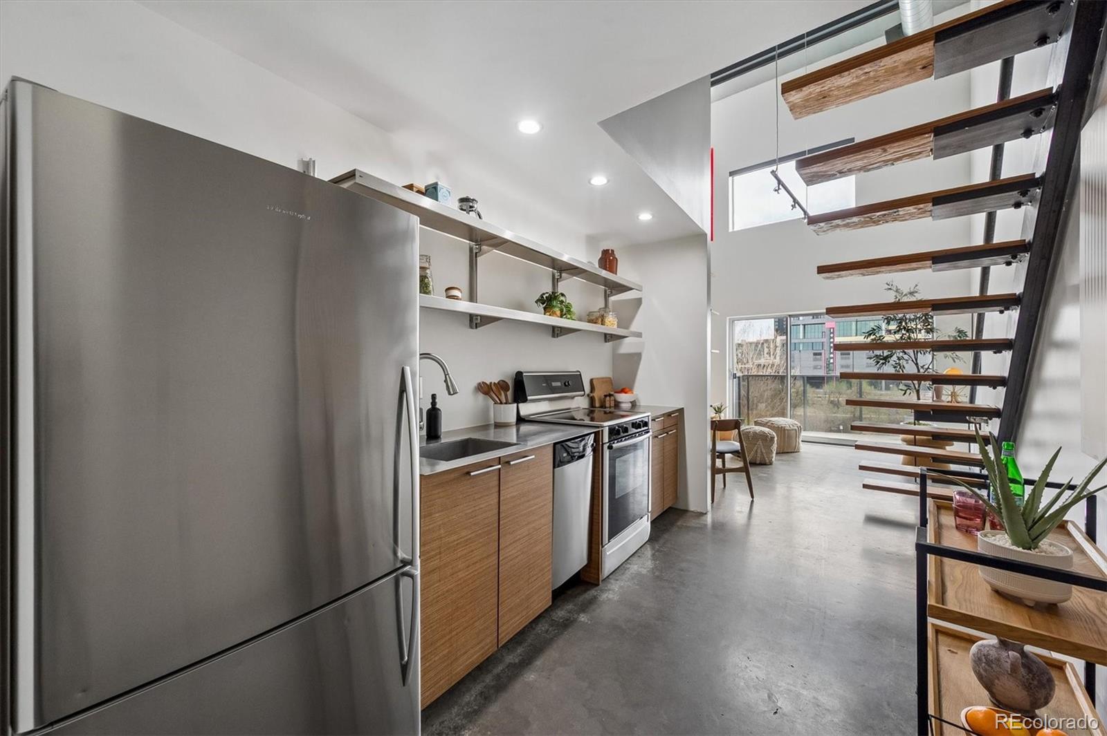3457 Ringsby Court, Unit 347 Denver, CO 80216 - Photo 8 of 22 a kitchen with stainless steel appliances a refrigerator and a stove
