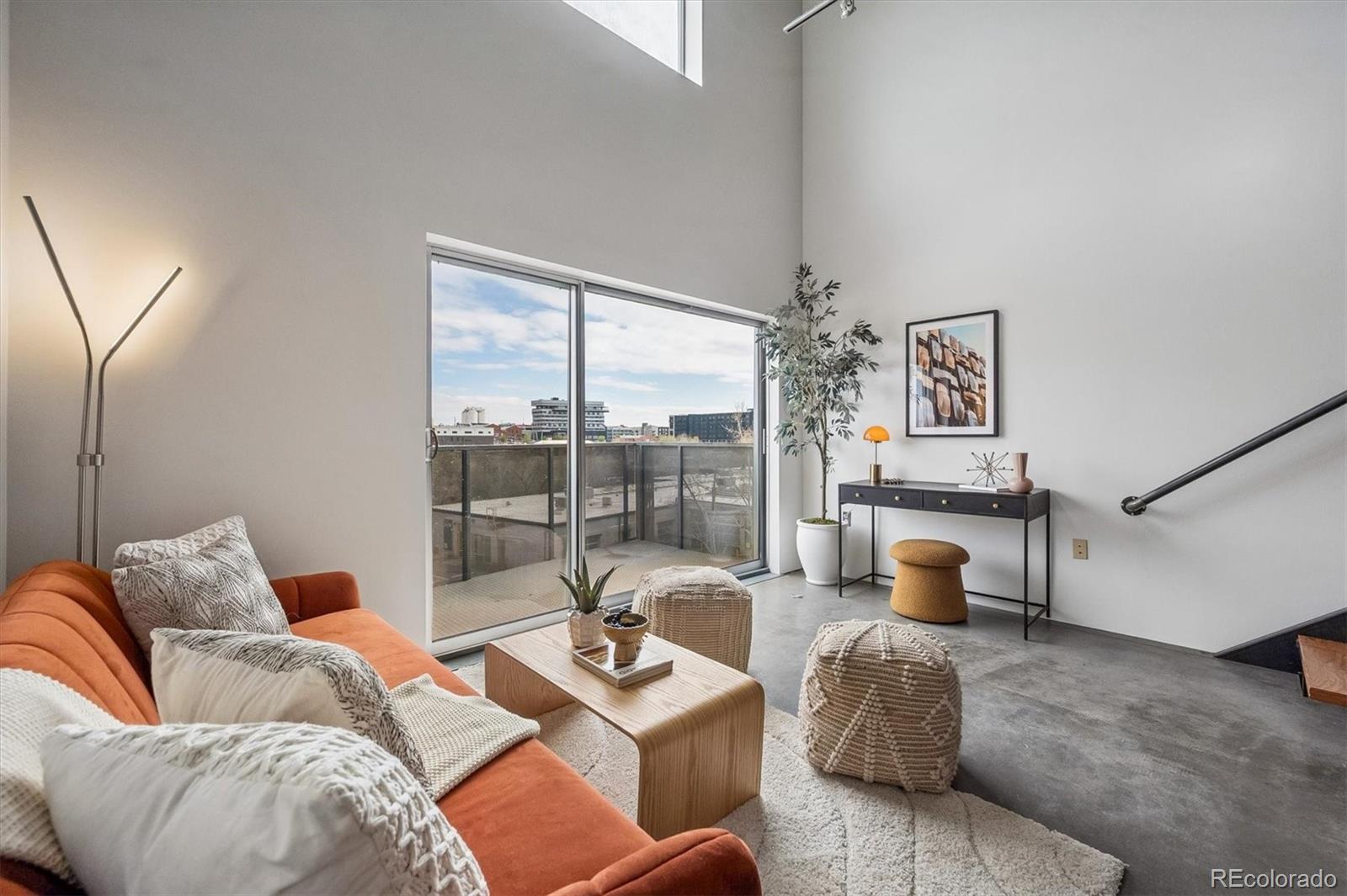 3457 Ringsby Court, Unit 347 Denver, CO 80216 - Photo 9 of 22 a living room with furniture and a large window