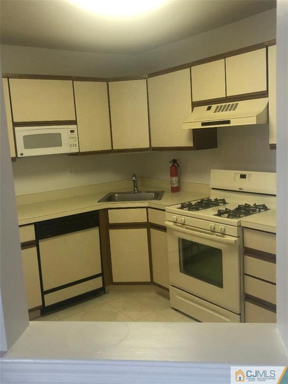 2702 Ridgefield Court, Unit 2702 Helmetta, NJ 08828 - Photo 3 of 8 a kitchen with a sink stove and cabinets